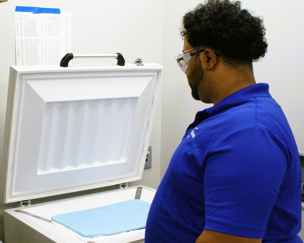 Engineer Standing Over a Freezer Containing Frozen Epoxy